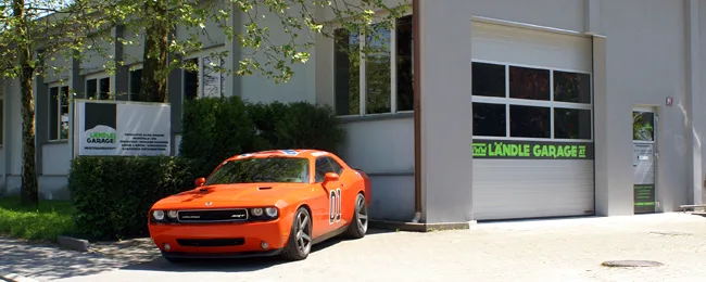 Außenansicht der Ländlegarage mit orangefarbenem Fahrzeug